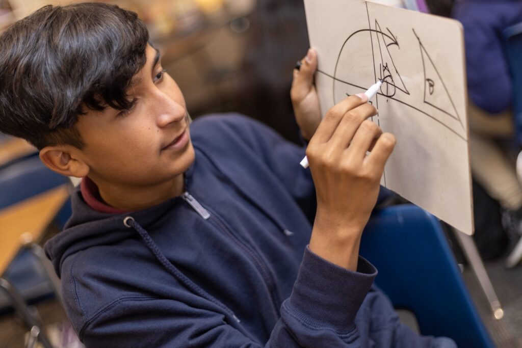 Student learns math on a whiteboard